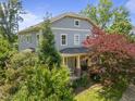 Charming two-story home boasts inviting curb appeal with landscaped yard and covered front porch at 445 S Greensboro St, Carrboro, NC 27510