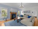 Cozy living room featuring fireplace, hardwood floors, and plush sofa at 445 S Greensboro St, Carrboro, NC 27510