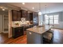 Gourmet kitchen with granite countertops, stainless steel appliances, dark wood cabinets, and a kitchen island at 45 Carriden Dr, Youngsville, NC 27596