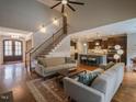Open-concept living space with hardwood floors and staircase that connects to a modern kitchen at 45 Carriden Dr, Youngsville, NC 27596