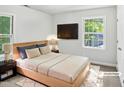 Cozy bedroom with natural light, a modern bed frame, and a mounted television at 4601 Pemberton Dr, Raleigh, NC 27609