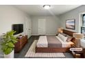 This staged bedroom features modern furniture, decor and a large screen television at 4601 Pemberton Dr, Raleigh, NC 27609