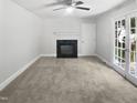 Bright living room with fireplace, ceiling fan, French doors, and neutral tones at 4601 Pemberton Dr, Raleigh, NC 27609