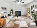Bright living room with fireplace, ceiling fan, French doors, and neutral tones at 4601 Pemberton Dr, Raleigh, NC 27609