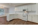 Well-lit kitchen with white cabinets, modern appliances, and tile backsplash at 505 #106 Alamance Rd, Burlington, NC 27215