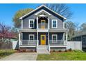 Charming two-story home with a welcoming front porch, yellow door, and well-maintained lawn at 613 Canal St, Durham, NC 27701