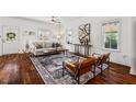 Bright living room with hardwood floors, neutral sofa, stylish rug and two brown mid-century chairs at 613 Canal St, Durham, NC 27701