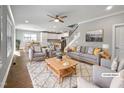 Sunlit living room featuring a gray sofa, stylish furniture, and an open floor plan that connects to the kitchen at 6233 Reagan Ln, Wake Forest, NC 27587