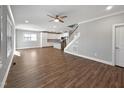 Open floor plan showcasing a staircase, living area, and a modern kitchen with white cabinets and stainless appliances at 6233 Reagan Ln, Wake Forest, NC 27587