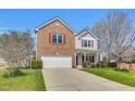 Charming two-story home with a brick and siding exterior, attached garage, and well-manicured front lawn at 6817 Osprey Landing Dr, Wendell, NC 27591