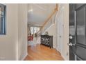 Bright foyer featuring hardwood floors, staircase, and decorative cabinet, welcoming guests at 7920 Leonardo Dr, Durham, NC 27713
