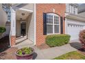 Inviting front porch with brick accents, stylish lighting, and lush green landscaping at 7920 Leonardo Dr, Durham, NC 27713