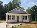 Charming single-story home featuring a welcoming front porch, black shutters, and durable vinyl siding at 87 Legolas Ct, Middlesex, NC 27557