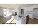 Well-lit kitchen featuring an island with granite countertops, stainless steel appliances and open floor plan at 87 Legolas Ct, Middlesex, NC 27557