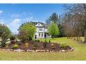 Beautiful two-story house with manicured lawn and various trees and bushes at 913 Clayton Rd, Angier, NC 27501
