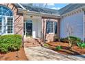 Inviting front entrance with brick steps, a classic black door, and well-maintained landscaping at 100 Pebble Ridge Farms Ct, Cary, NC 27513
