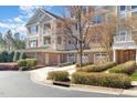 Three-story home featuring garages, multiple windows, dormers, neutral colors, and balconies on a sunny day at 10411 Rosegate Ct # 202, Raleigh, NC 27617