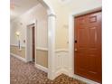 Hallway with neutral walls, white trim, patterned carpet, and doors leading to various rooms and amenities at 10411 Rosegate Ct # 202, Raleigh, NC 27617