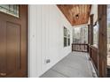 Covered side porch with wood railing, wood-clad ceiling and concrete floor at 109 Mohawk Dr, Louisburg, NC 27549
