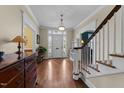 Inviting foyer with hardwood floors, white trim, staircase, and coat storage at 1106 Aycock Ave, Burlington, NC 27215