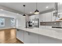 Bright, modern kitchen boasts white cabinets, stainless steel appliances, and a large island at 1222 Coach Station Alley # 101, Raleigh, NC 27601