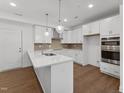 Bright kitchen featuring white cabinetry, quartz countertops, and stainless steel appliances at 1226 Coach Station Alley # 101, Raleigh, NC 27601