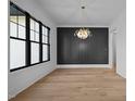 Bright dining area features hardwood floors, a modern chandelier, and a large window, perfect for entertaining at 1318 Ivy Ln, Raleigh, NC 27609