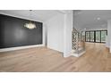 Open concept dining room showcases hardwood floors, decorative black wall paneling, and modern stairway at 1318 Ivy Ln, Raleigh, NC 27609