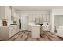 A spacious kitchen featuring stainless steel appliances, a kitchen island with seating, and light wood-tone cabinets at 1569 Goldfinch Perch Ln, Knightdale, NC 27545