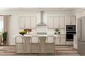 A kitchen featuring stainless steel appliances, a kitchen island with seating, and light wood-tone cabinets at 1569 Goldfinch Perch Ln, Knightdale, NC 27545