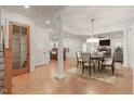 Elegant dining room featuring hardwood floors, classic columns, and a stylish chandelier over the dining table at 162 Arabella Ct, Cary, NC 27518