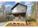 A modern two-story home with a welcoming porch, a metal roof, and a contemporary design at 168 Daphine Dr, Hillsborough, NC 27278