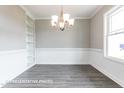 Bright dining room features a chandelier, wainscoting, and built-in shelving at 169 Tigris Ct, Zebulon, NC 27597
