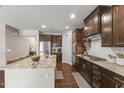 Modern kitchen with dark wood cabinets, stainless appliances, and granite countertops at 1715 Capstone Dr, Durham, NC 27713