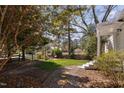 Fenced backyard features lush greenery, a small patio, and mature trees offering shade at 202 High St, Carrboro, NC 27510