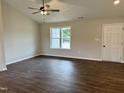 Bright living room featuring dark wood-look flooring and a large window at 207 N Movado Trl, Kenly, NC 27542