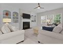 Bright living room with built-in shelves, a fireplace, and large windows that offer plenty of natural light at 2220 Rainy Lake St, Wake Forest, NC 27587