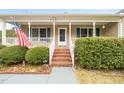 Inviting front porch with brick steps, white railing, and an American flag display at 2782 N Shiloh Rd, Garner, NC 27529