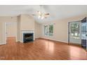 Spacious living room with a cozy fireplace, ceiling fan, and natural light at 2782 N Shiloh Rd, Garner, NC 27529