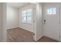 Bright entryway featuring a white door with glass panel and a view into a room with wood-look floors at 291 Hanging Elm Ln, Fuquay Varina, NC 27526