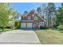 Charming two-story brick home with a two-car garage, driveway, and manicured lawn at 308 Sylvan Way, Chapel Hill, NC 27516
