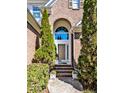 Inviting arched entryway with brick steps and decorative plants, enhancing curb appeal at 4 Teahouse Ct, Durham, NC 27707