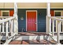 Close-up of front door with bright red paint, security camera, and welcoming decor at 4532 Draper Rd, Raleigh, NC 27616