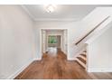 Bright foyer featuring hardwood floors, neutral walls, and a staircase with a wooden handrail at 4893 Grosbeak Ct, Mebane, NC 27302