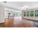 Open-concept living area with hardwood floors, ceiling fan, and abundant natural light at 4893 Grosbeak Ct, Mebane, NC 27302