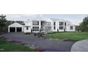 Elegant modern home with a three-car garage, manicured landscaping, and a long, paved driveway at 4900 Foxridge Dr, Raleigh, NC 27614