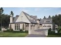 Home exterior featuring multi-car garages, grey roof, and manicured landscaping at 4921 Foxridge Dr, Raleigh, NC 27614