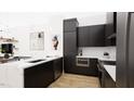 Modern kitchen with a large island with a white countertop, dark cabinets and stainless steel appliances at 512 Gordon St # 402, Durham, NC 27701