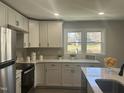 Bright kitchen features white cabinetry, stainless steel appliances, and quartz countertops at 512 Texas Ave, Burlington, NC 27217
