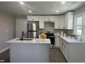 Modern kitchen with stainless steel appliances, white cabinets, and sleek countertops at 512 Texas Ave, Burlington, NC 27217